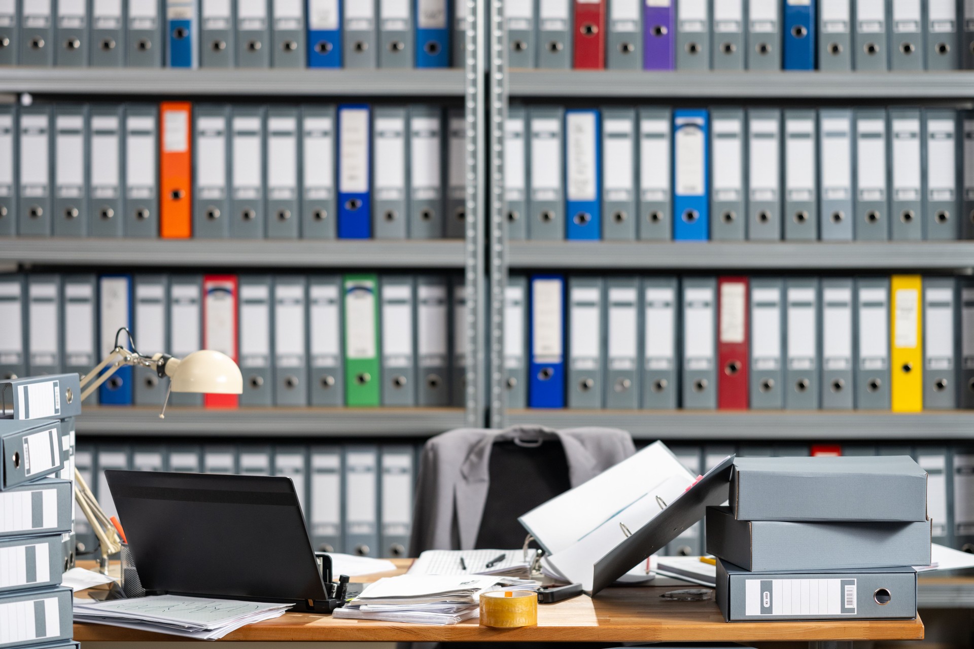 Organized Office Desk with Shelves of Colorful Binders